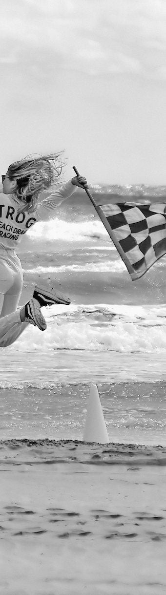 Dynamic Start at TROG: Adrenaline-Packed Flag Girl Soars Over Beach - Breathtaking Black & White Energy Photo Poster Print
